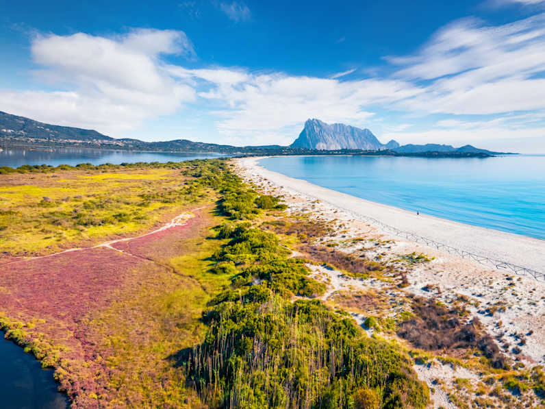 Ein weitläufiger Strand mit Bergen im Hintergrund